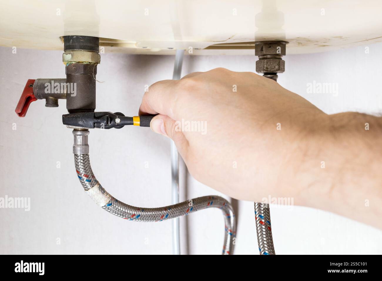 idraulico fissa manualmente la valvola con una chiave regolabile sulla caldaia a casa Foto Stock