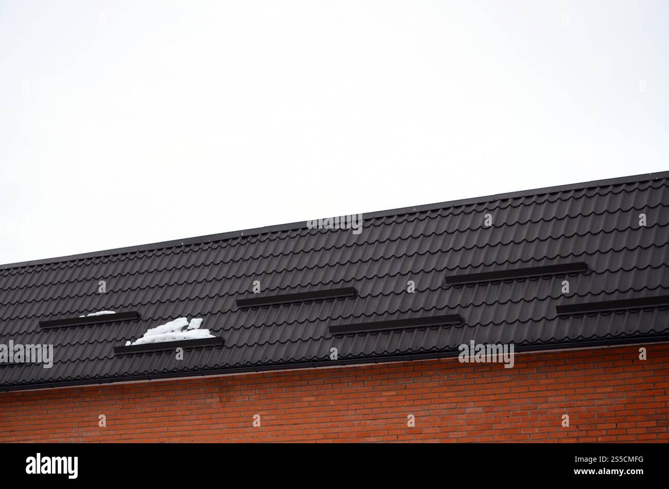 Tegole in metallo marrone. Cerniere per tetti in metallo - costruzione di tetti Foto Stock