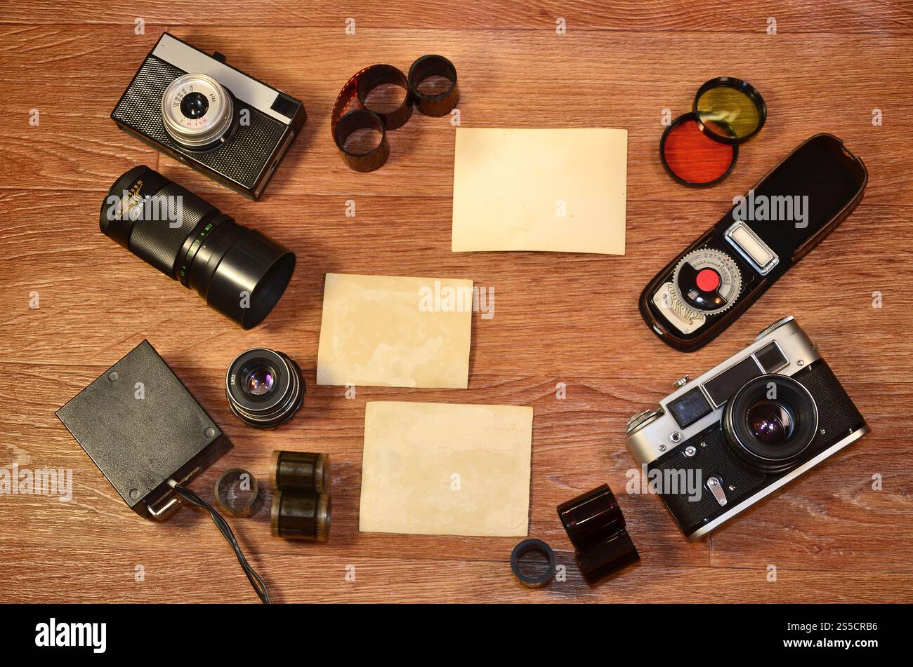 Fotocamera d'epoca, accessori fotografici e cornici vuote su un tavolo in legno. Natura morta con spazio di copia. Vista dall'alto. Immagine dai toni retrò in beige Foto Stock