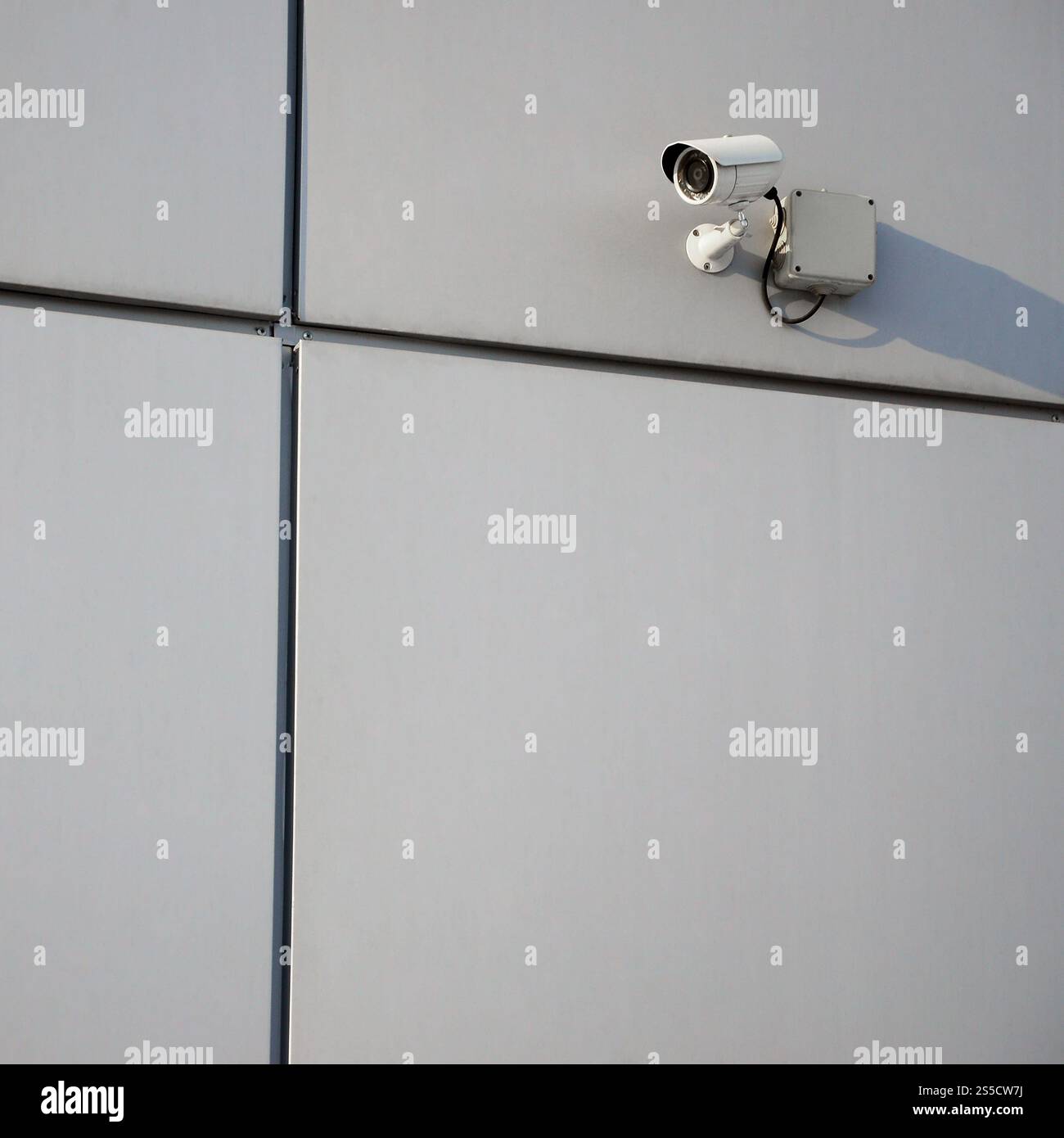 Telecamera di sorveglianza bianca integrata nella parete metallica dell'edificio degli uffici Foto Stock