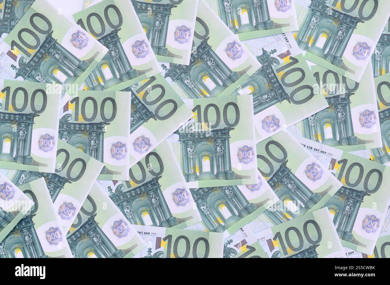 Modello di sfondo di una serie di tagli monetari verdi di 100 euro. Un sacco di soldi forma un mucchio infinito Foto Stock