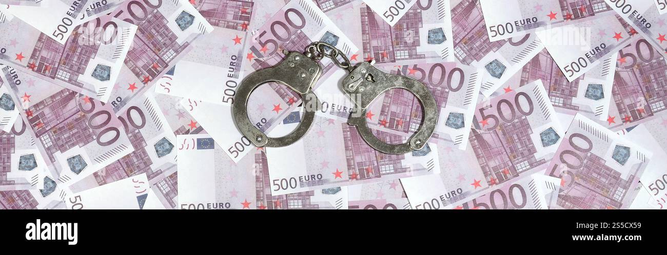 Manette su sfondo cinquecento euro. Concetto di criminalità finanziaria, denaro sporco e corruzione - 500 fatture di denaro e manette di acciaio sporche Foto Stock