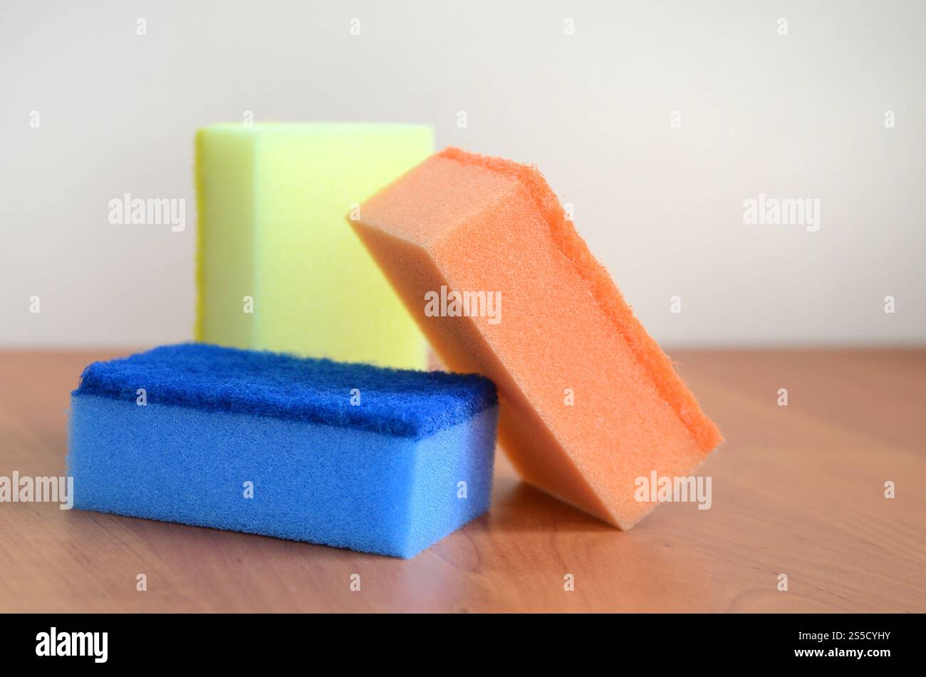 Un paio di spugne cucina giacciono su una cucina in legno il ripiano del bancone. Gli oggetti colorati per il lavaggio di stoviglie e pulizia in casa sono pronto per l'uso Foto Stock