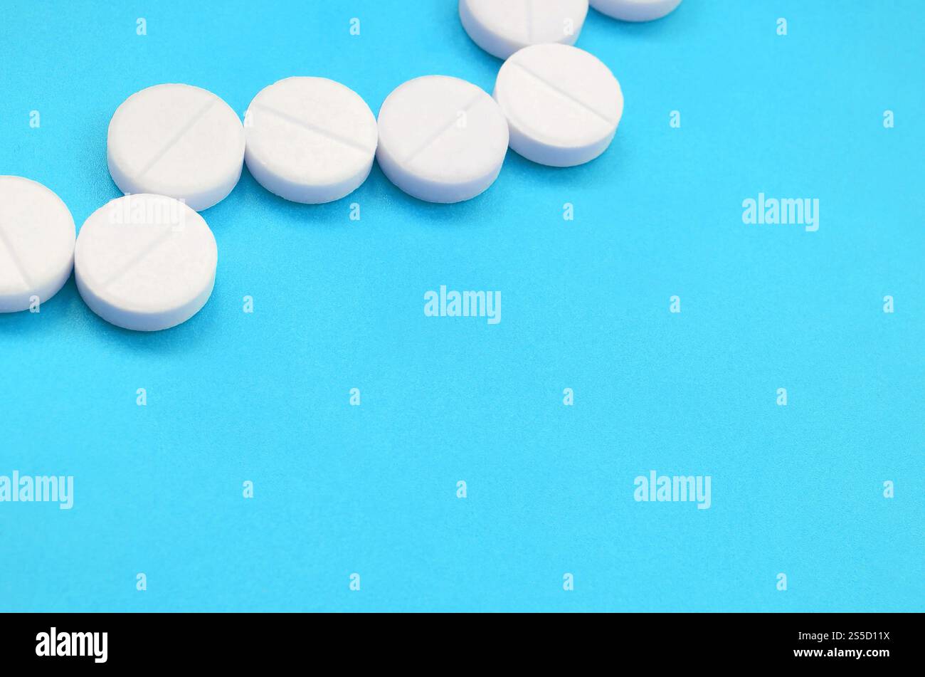 Un paio di compresse bianche giacciono su un blu brillante superficie di sfondo. Immagine di sfondo sul farmaceutico e medico, argomenti Foto Stock