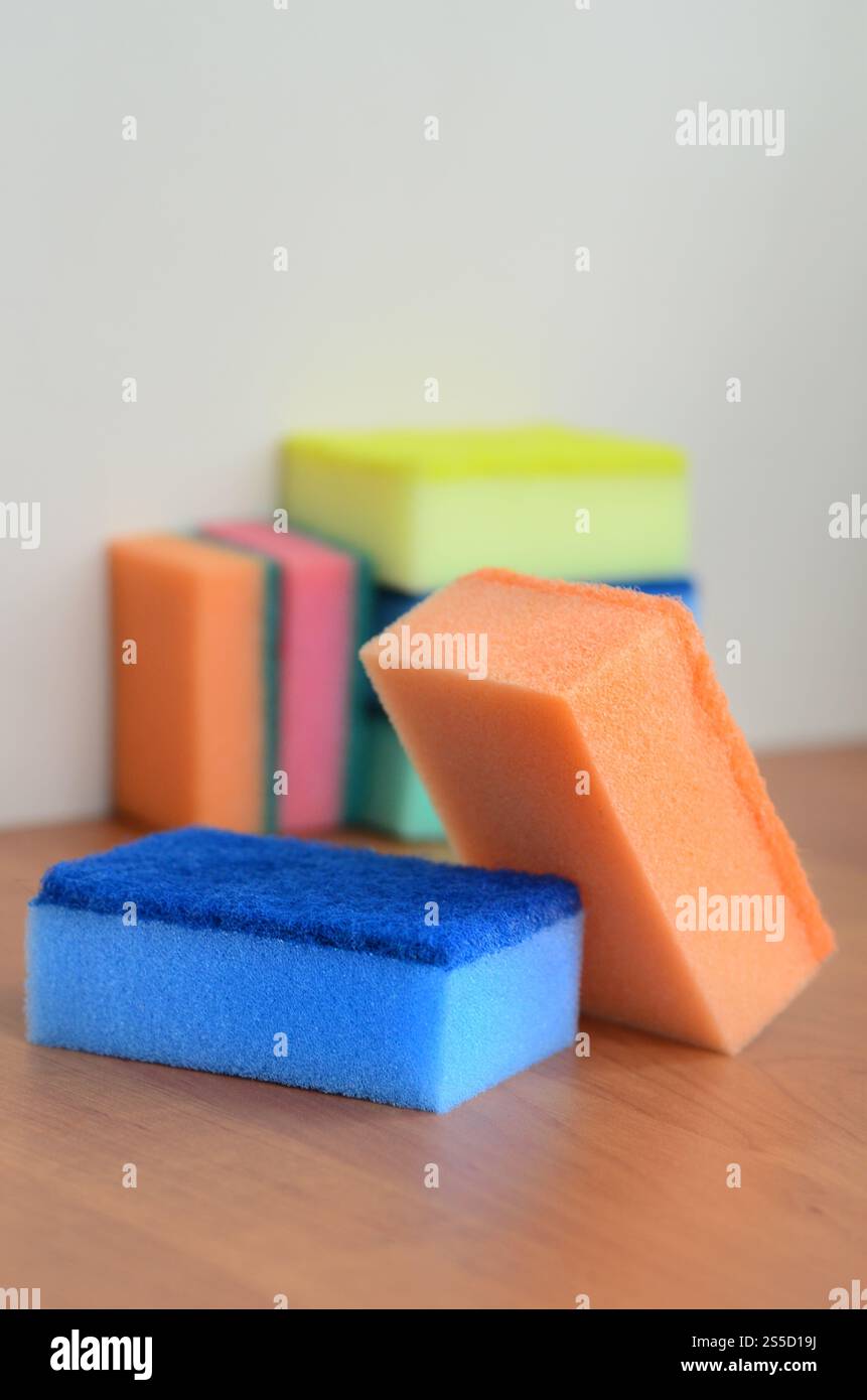 Un paio di spugne cucina giacciono su una cucina in legno il ripiano del bancone. Gli oggetti colorati per il lavaggio di stoviglie e pulizia in casa sono pronto per l'uso Foto Stock