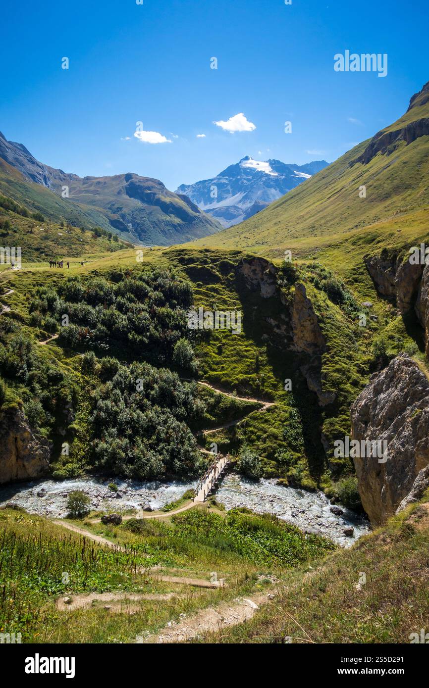 Fiume di montagna e ponte in legno nel Parco Nazionale della Vanoise Valle alpina, Savoia, alpi francesi. Fiume di montagna e ponte in legno nel Parco nazionale della Vanoise Foto Stock