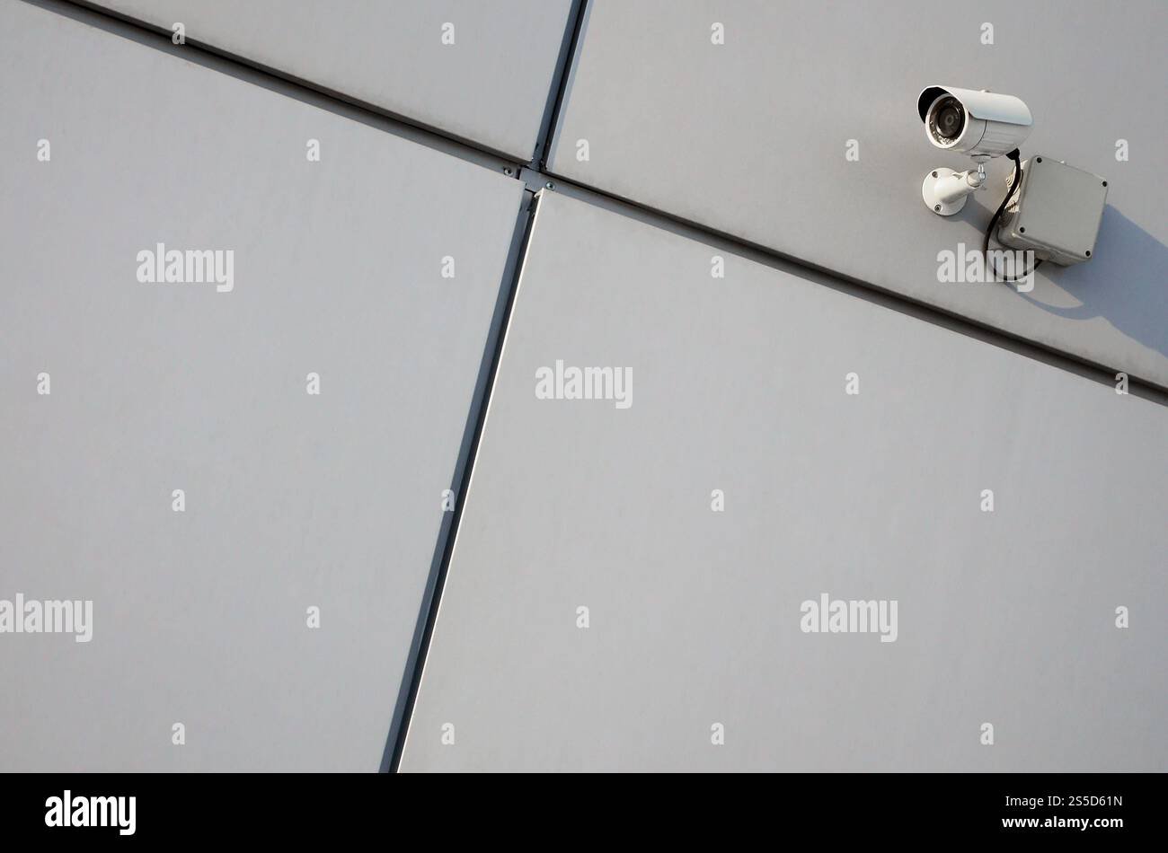 Telecamera di sorveglianza bianca integrata nella parete metallica dell'edificio degli uffici Foto Stock