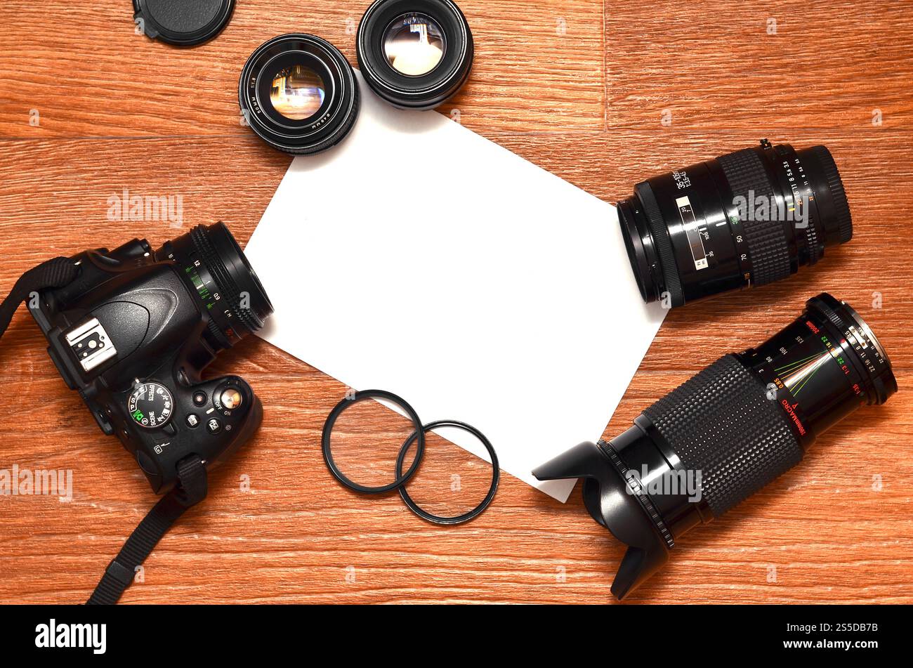 STILL Life con un set di fotografi professionisti. Fotocamera con molti obiettivi e accessori fotografici su una superficie in legno marrone con un sito per Foto Stock