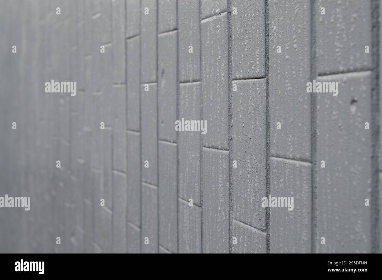 La struttura del muro dalla vecchia piastrella, dipinta di grigio sotto l'influenza della condensazione. Molte piccole gocce e macchie d'acqua sulla parete Foto Stock