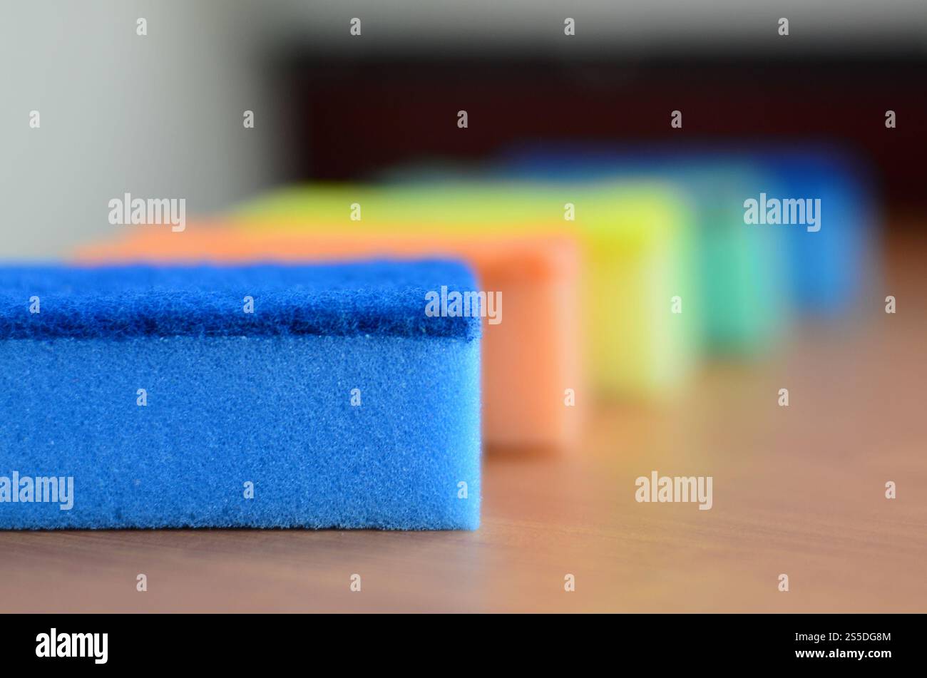 Un paio di spugne cucina giacciono su una cucina in legno il ripiano del bancone. Gli oggetti colorati per il lavaggio di stoviglie e pulizia in casa sono pronto per l'uso Foto Stock