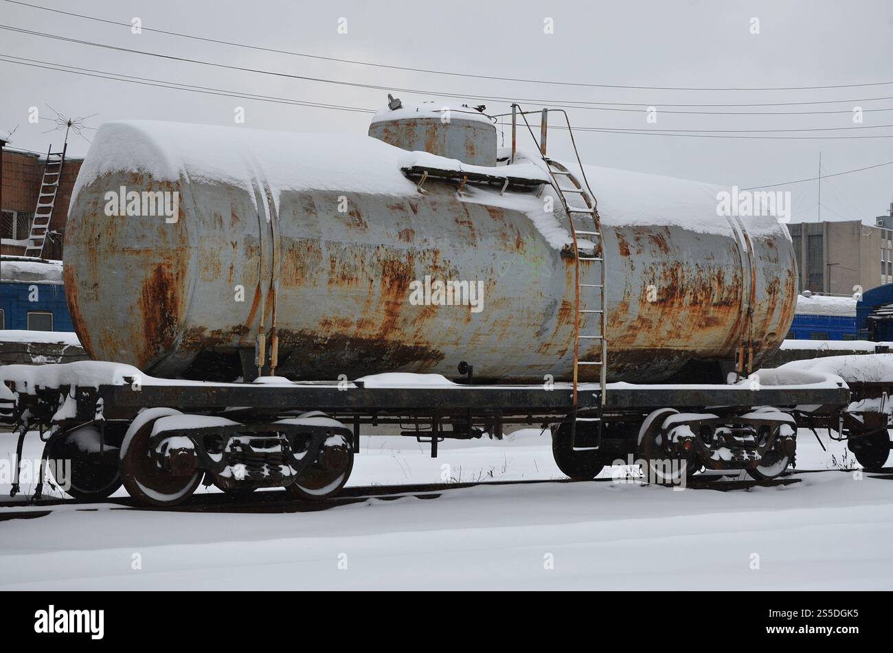 Foto dettagliata di un vagone ferroviario ghiacciato innevato. Un frammento dei componenti della vettura merci sulla ferrovia nelle nevose serali invernali. Foto Stock