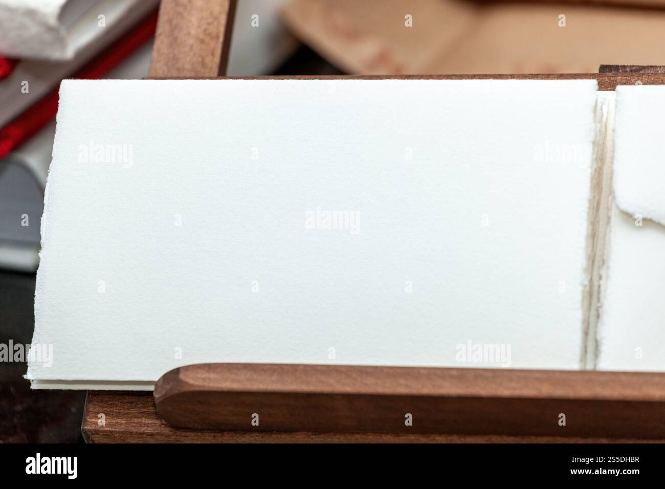 Primo piano di carta bianca fatta a mano esposta su una scatola di legno, ideale per inviti di nozze o eleganti cancellerie Foto Stock