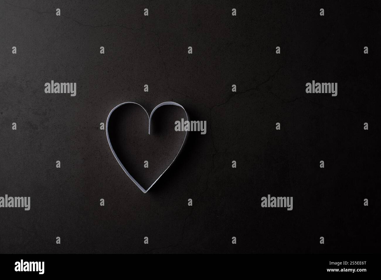 Carta bianca a forma di cuore in ombra su sfondo nero Foto Stock Carta bianca a forma di cuore in ombra su sfondo nero Foto Stock