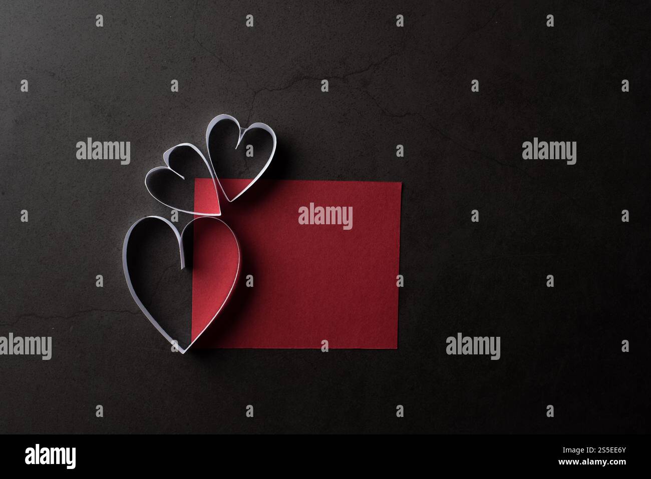 Carta bianca a forma di cuore in ombra e cartellino rosso su sfondo nero Foto Stock Carta bianca a forma di cuore in ombra e cartellino rosso su sfondo nero Foto Stock
