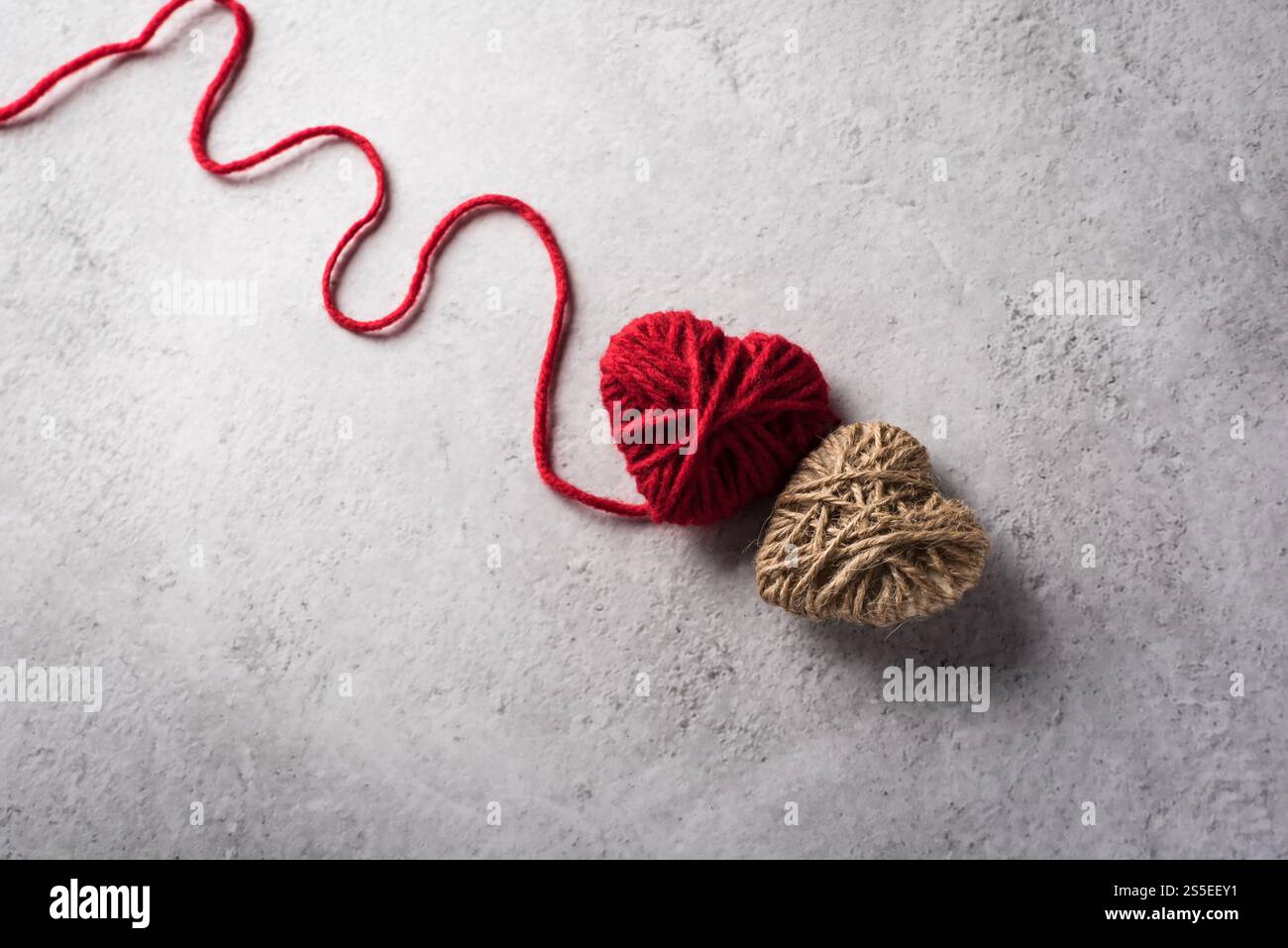 Il cuore rosso del filo ha modellato sullo sfondo della parete Foto Stock Il cuore rosso del filo ha modellato sullo sfondo della parete Foto Stock