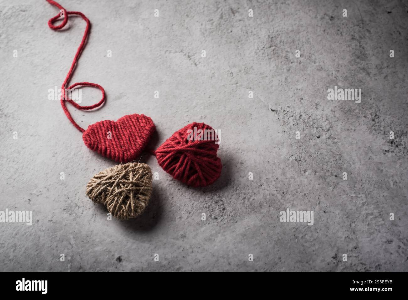 Il cuore rosso del filo ha modellato sullo sfondo della parete Foto Stock Il cuore rosso del filo ha modellato sullo sfondo della parete Foto Stock