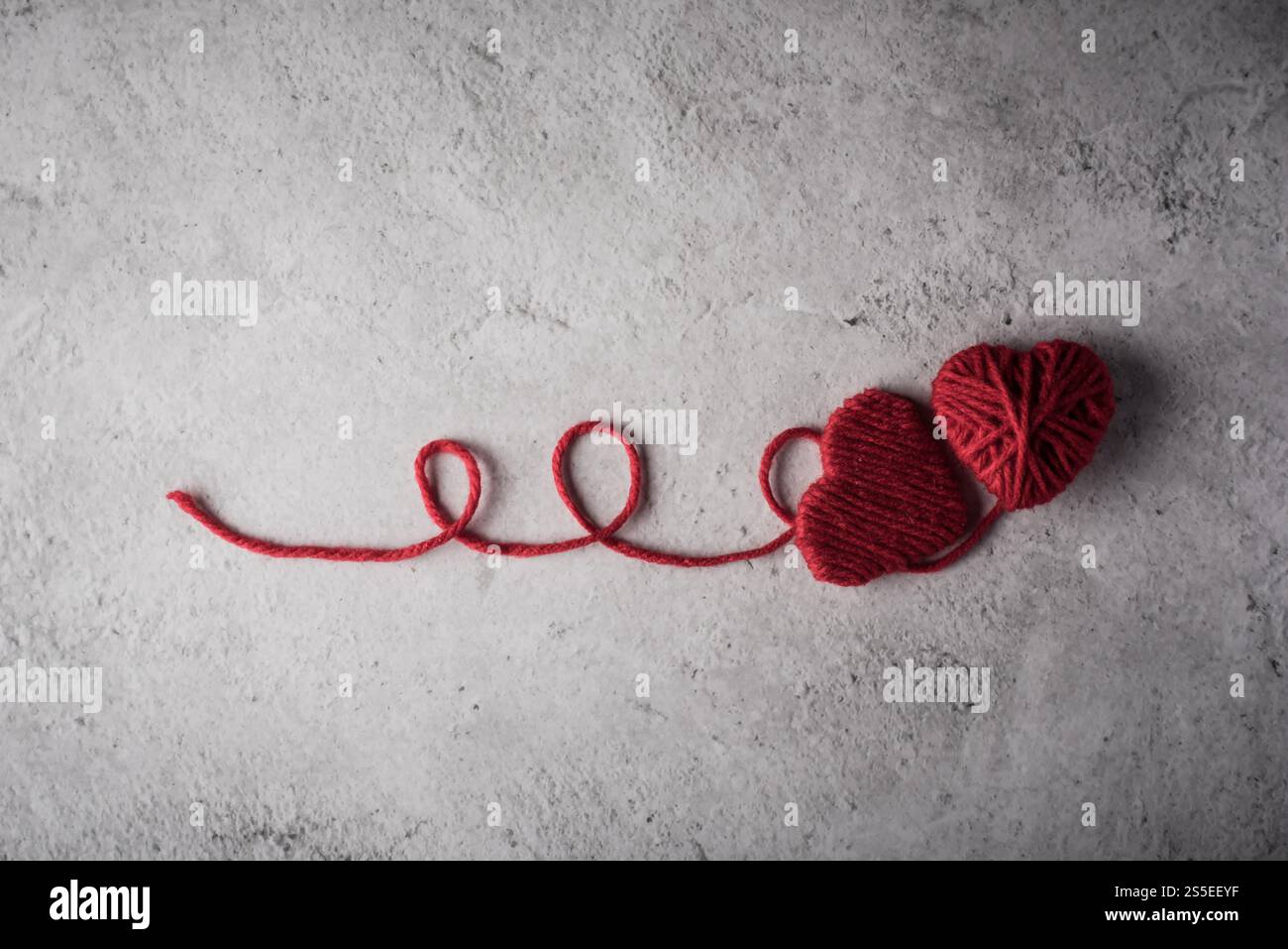 Il cuore rosso del filo ha modellato sullo sfondo della parete Foto Stock Il cuore rosso del filo ha modellato sullo sfondo della parete Foto Stock