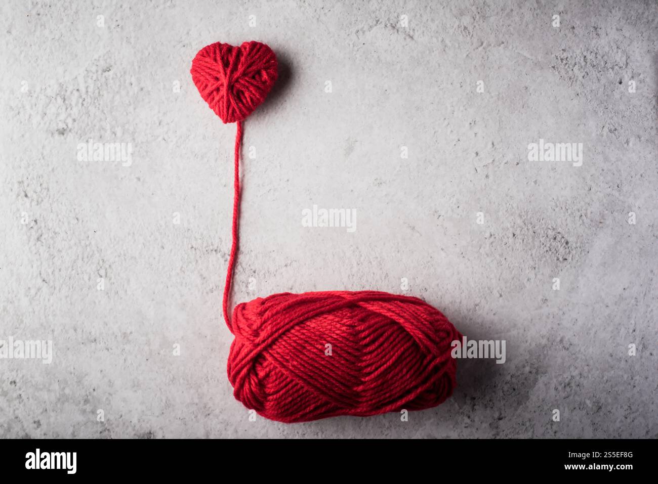 Il cuore rosso del filo ha modellato sullo sfondo della parete Foto Stock Il cuore rosso del filo ha modellato sullo sfondo della parete Foto Stock