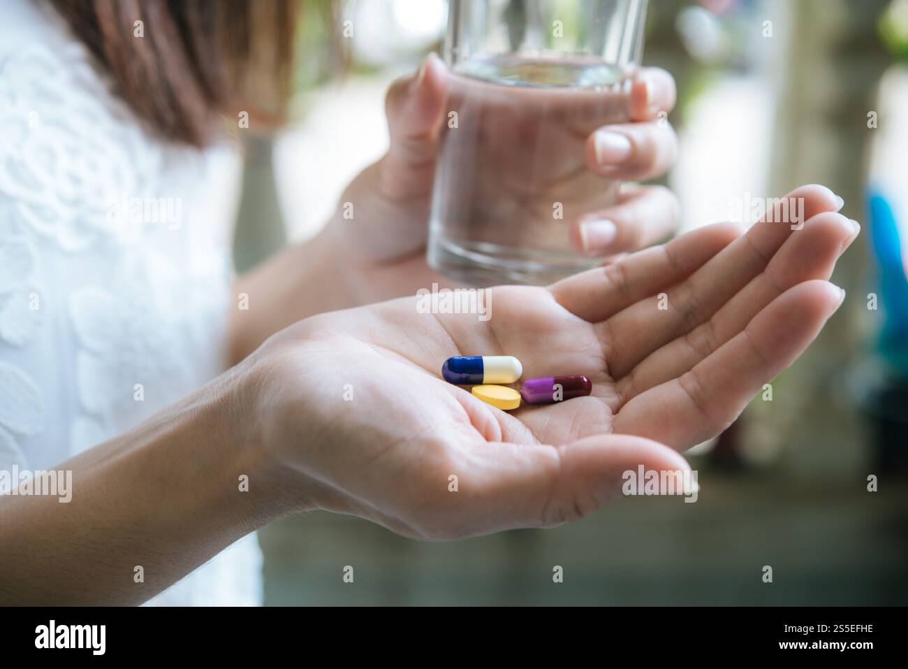 Le donne riversano le pillole di medicina dalla bottiglia Foto Stock