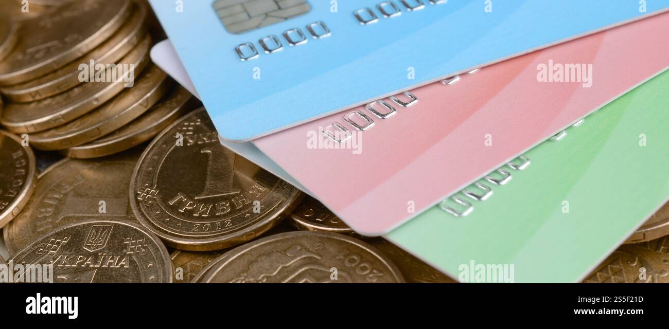 Le monete ucraine e le carte di credito colorate chiudono. Valuta dell'Ucraina. Bilanciamento del denaro e concetto di online banking. Wireless banking globale Foto Stock