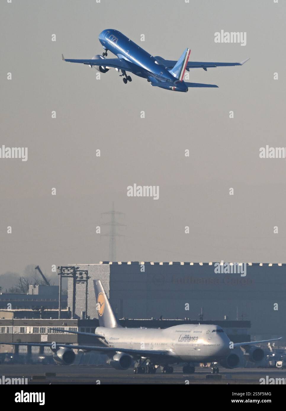 14 gennaio 2025, Assia, Francoforte sul meno: Un aeromobile della compagnia aerea di stato italiana Ita (sopra) decolla all'aeroporto di Francoforte su un Boeing 747-8 Lufthansa. Il gruppo Lufthansa vuole espandersi verso sud e sta progettando di acquisire una partecipazione in Ita. In un primo passo, Lufthansa vuole acquisire una quota di minoranza del 41% nel successore di Alitalia. Foto: Arne Dedert/dpa Foto Stock