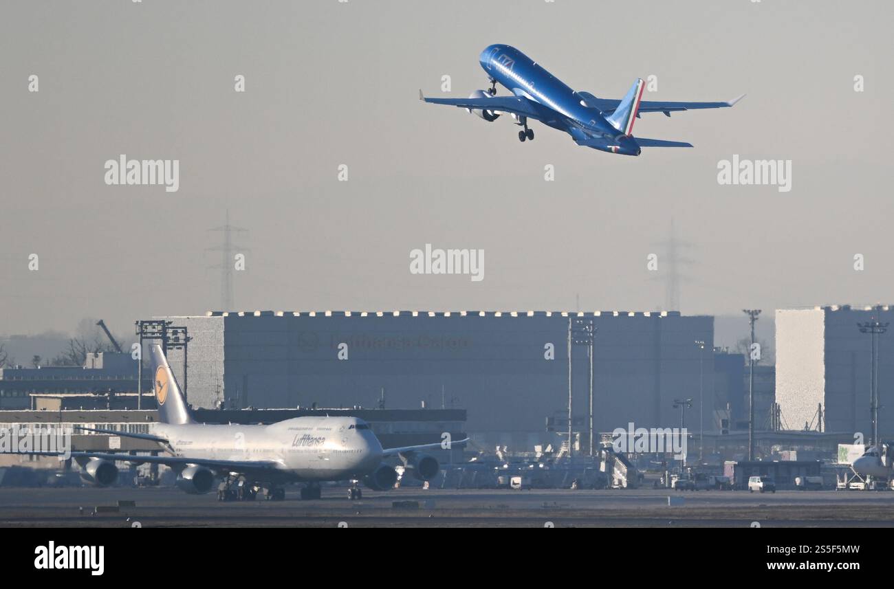 14 gennaio 2025, Assia, Francoforte sul meno: Un aeromobile della compagnia aerea statale italiana Ita (r) decolla all'aeroporto di Francoforte su un Boeing Lufthansa 747-8. Il gruppo Lufthansa vuole espandersi verso sud e sta progettando di acquisire una partecipazione in Ita. In un primo passo, Lufthansa vuole acquisire una quota di minoranza del 41% nel successore di Alitalia. Foto: Arne Dedert/dpa Foto Stock