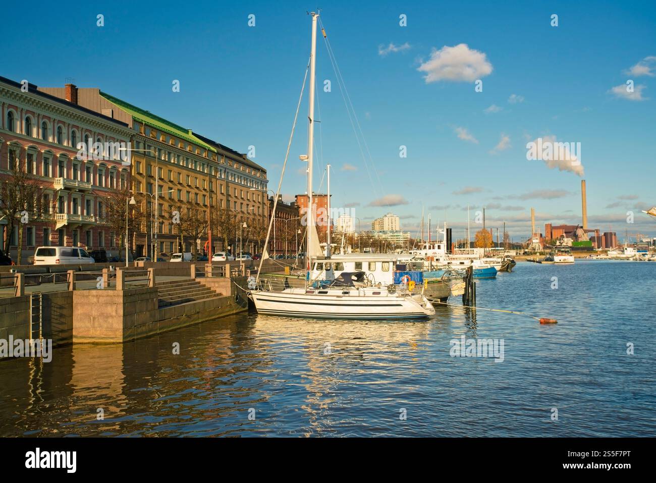 La barca a vela ormeggiata sul lungomare di Helsinki in una giornata di sole con edifici storici e un'area fumatori sullo sfondo, la Finlandia Foto Stock