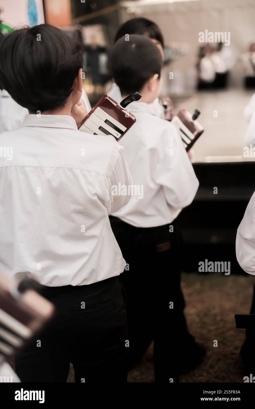 Gruppo di ragazzi delle scuole elementari con piano sulle mani in attesa di esibirsi sul palco Foto Stock