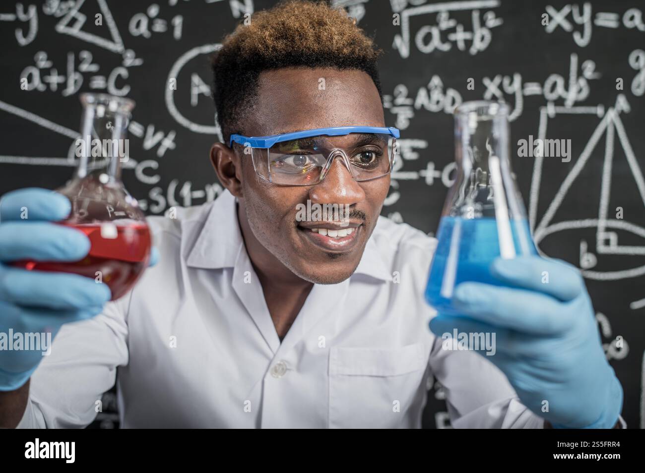 Gli scienziati guardano le sostanze chimiche blu cielo in vetro al laboratorio. Foto Stock