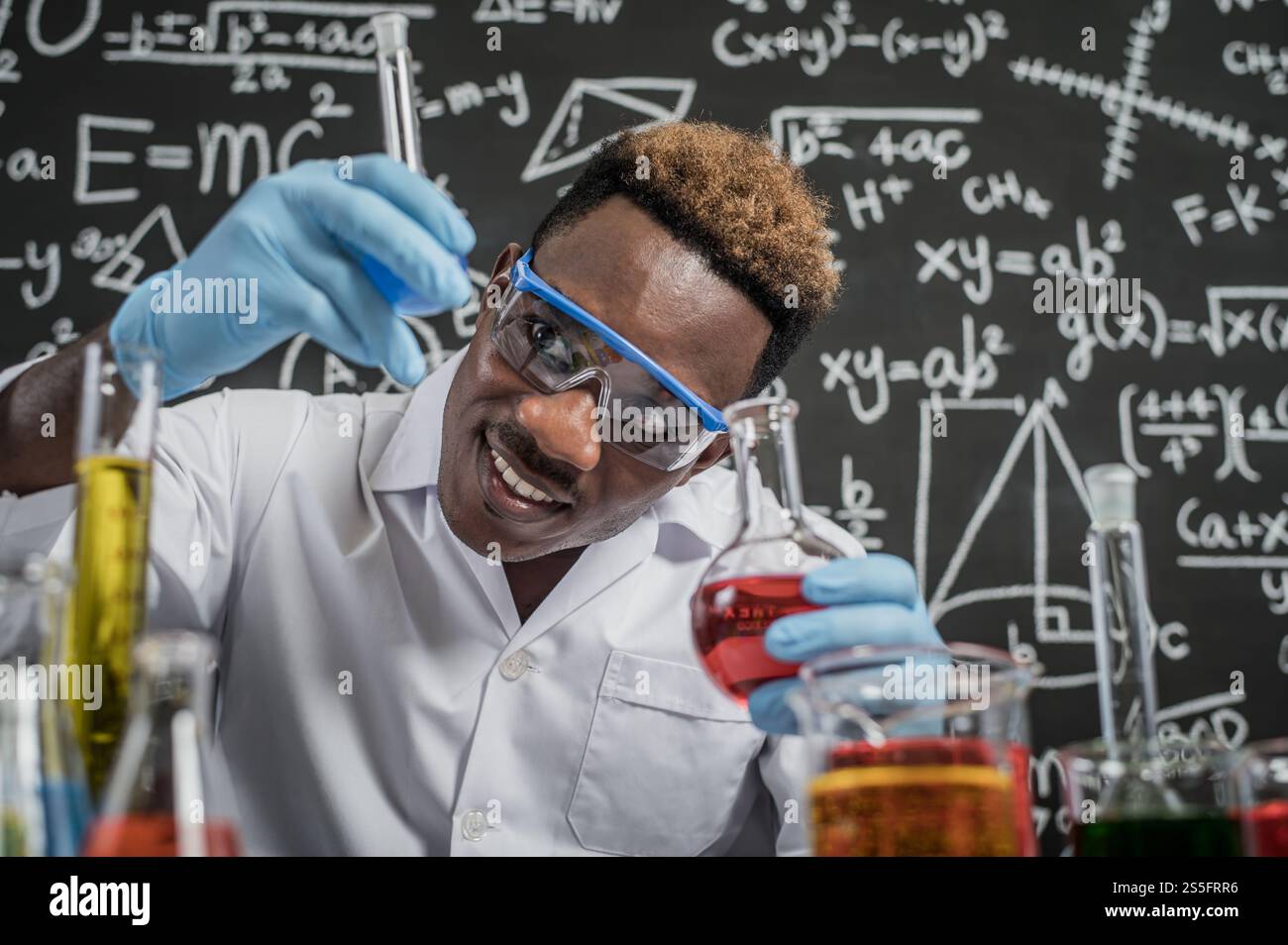 Gli scienziati guardano le sostanze chimiche blu cielo in vetro al laboratorio. Foto Stock