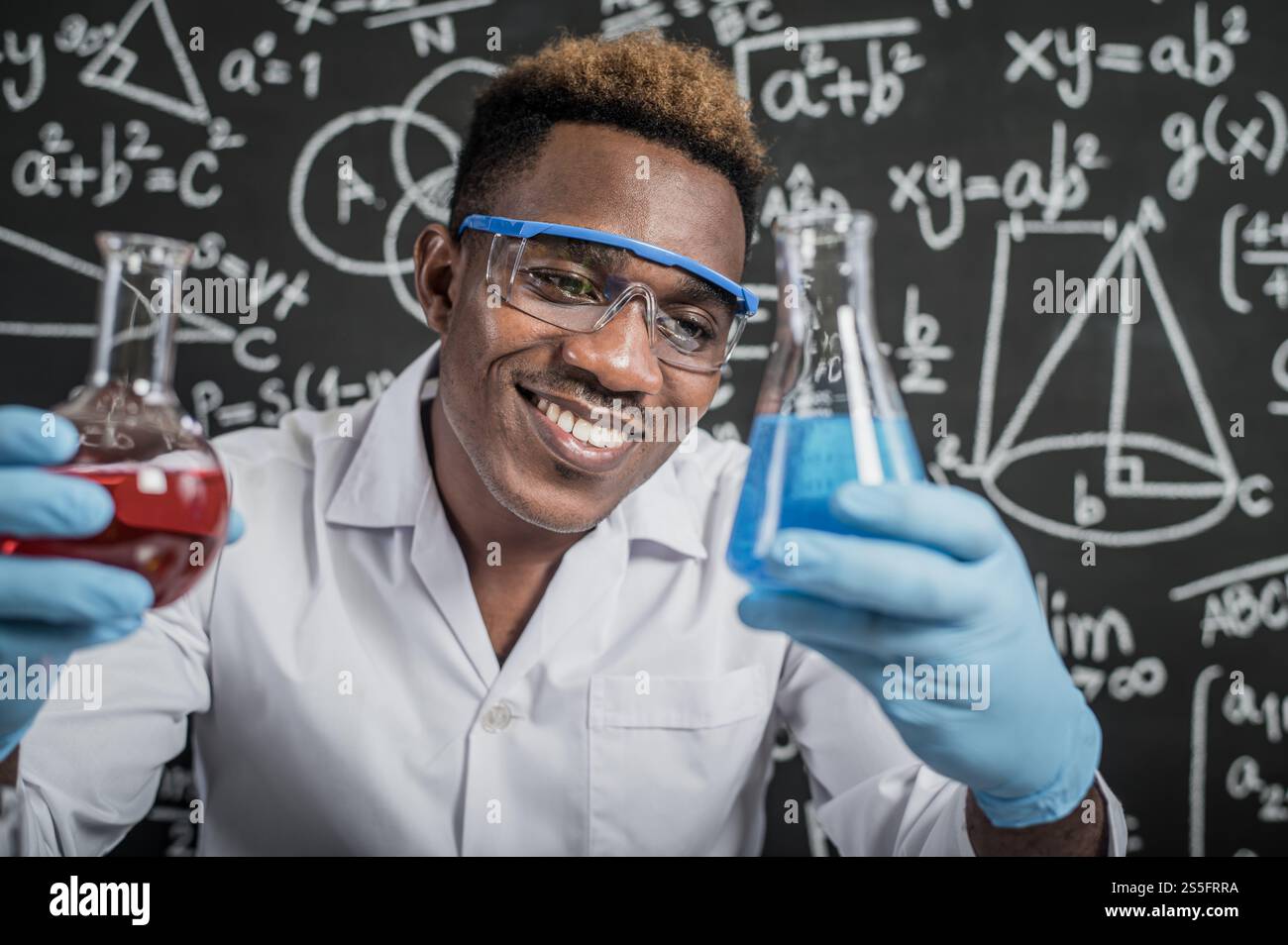 Gli scienziati guardano le sostanze chimiche blu cielo in vetro al laboratorio. Foto Stock
