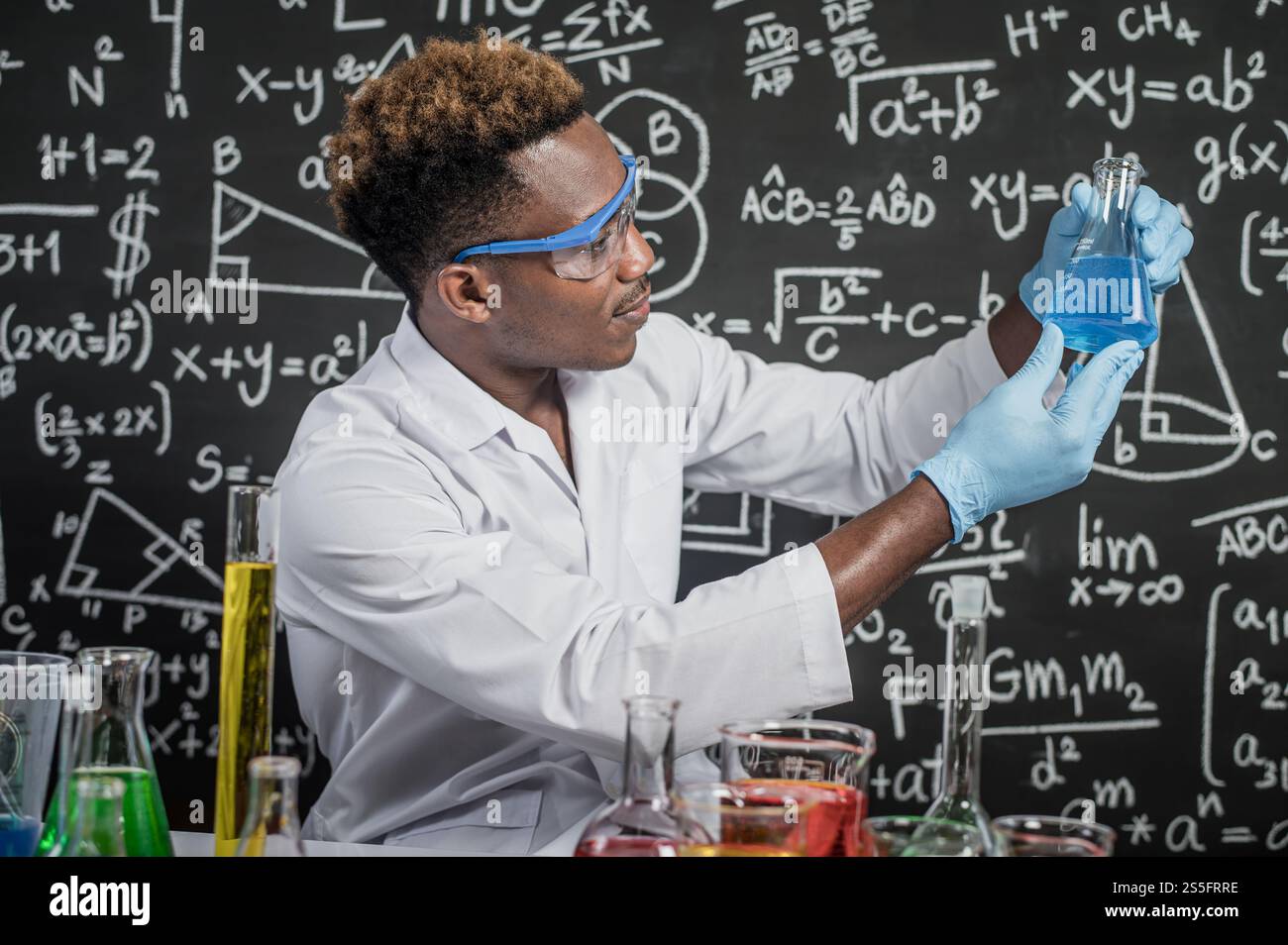 Gli scienziati guardano le sostanze chimiche blu cielo in vetro al laboratorio. Foto Stock
