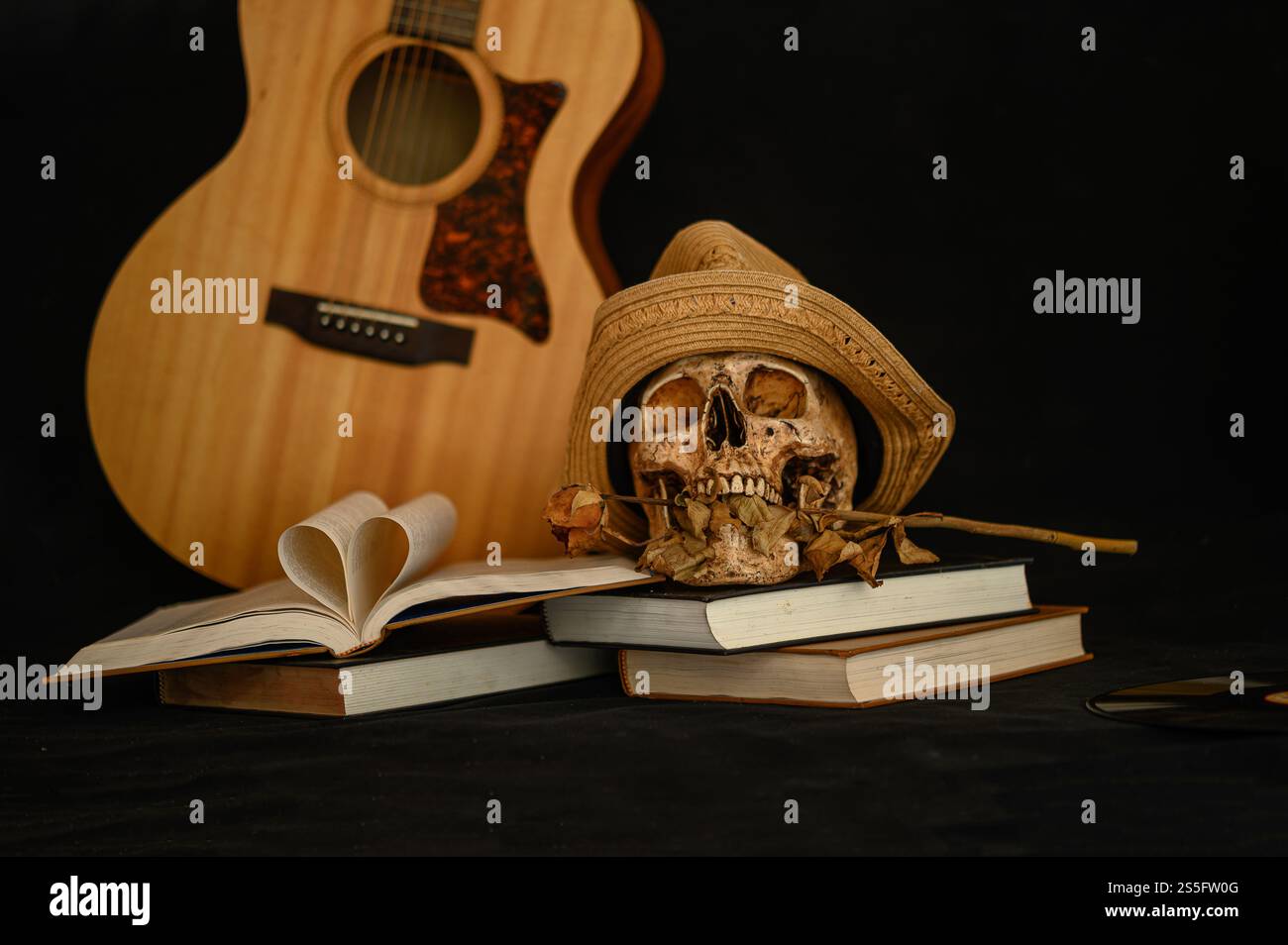 Natura morta con un libro a forma di cuore e un teschio in bocca con fiori secchi. Foto Stock Natura morta con un libro a forma di cuore e un teschio in bocca con fiori secchi. Foto Stock