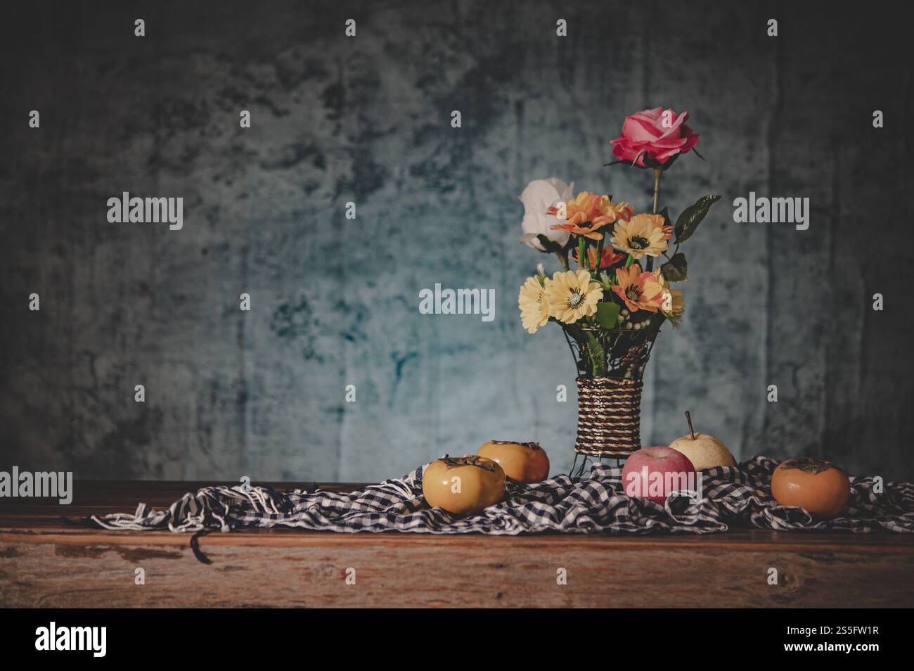 Natura morta con un vaso di fiori e frutta posto su un tessuto Foto Stock