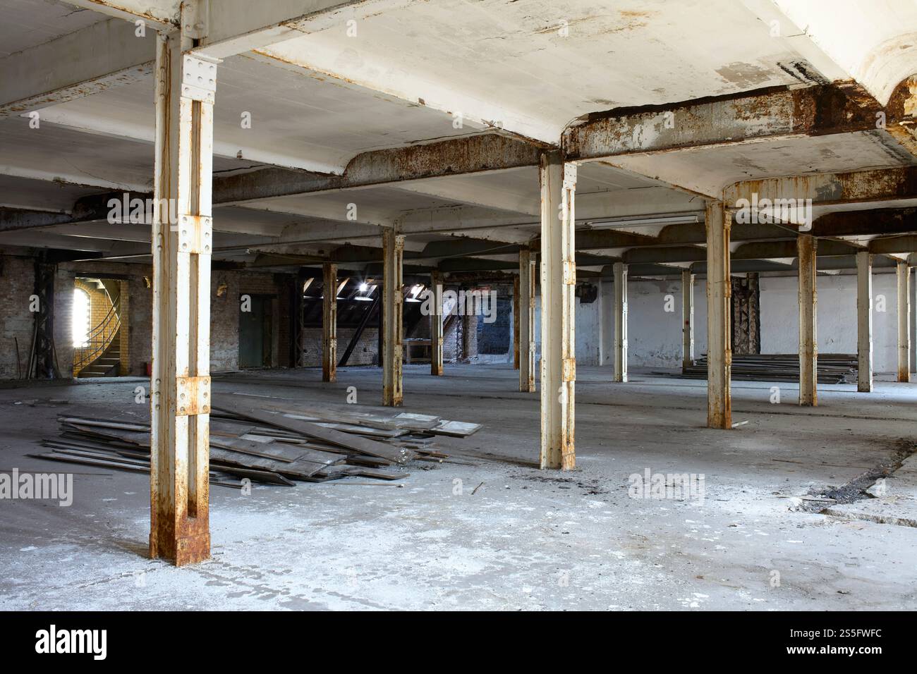 Edificio industriale abbandonato interno con colonne e detriti sparsi, Berlino, Germania Foto Stock