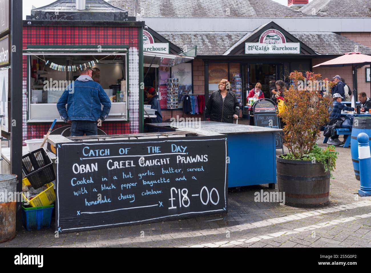 Oban, Argyll & Bute, porto e terminal dei traghetti per le isole sulla costa occidentale scozzese. Vendita di pesce al molo dei traghetti. Creel ha preso i gamberi. Foto Stock