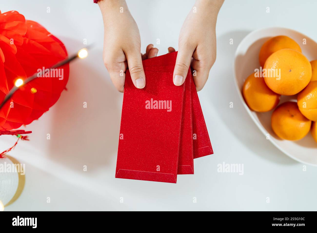 Donna asiatica che dà busta rossa per le celebrazioni del Capodanno lunare. Tenere la mano nella confezione rossa. Foto Stock