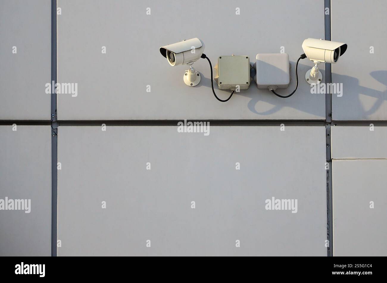 Telecamera di sorveglianza bianca integrata nella parete metallica dell'edificio degli uffici Foto Stock