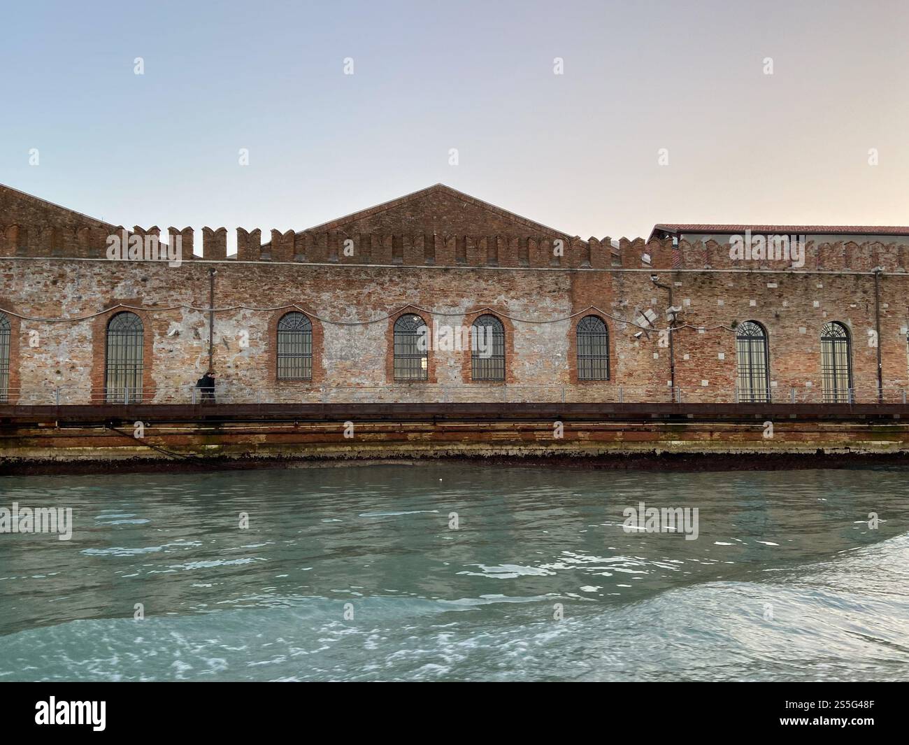 Vista frontale delle facciate delle vecchie scorte sul lungomare della città di Venezia dalla laguna veneta nel crepuscolo invernale Foto Stock
