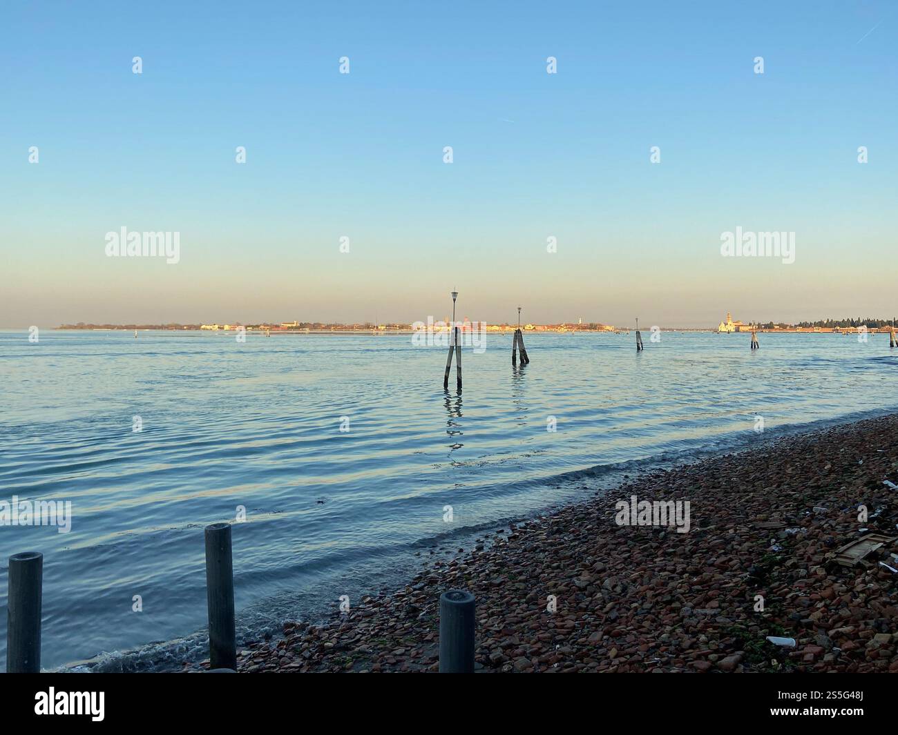 Vista sull'acqua della laguna veneta dalla città di Venezia al tramonto d'inverno Foto Stock