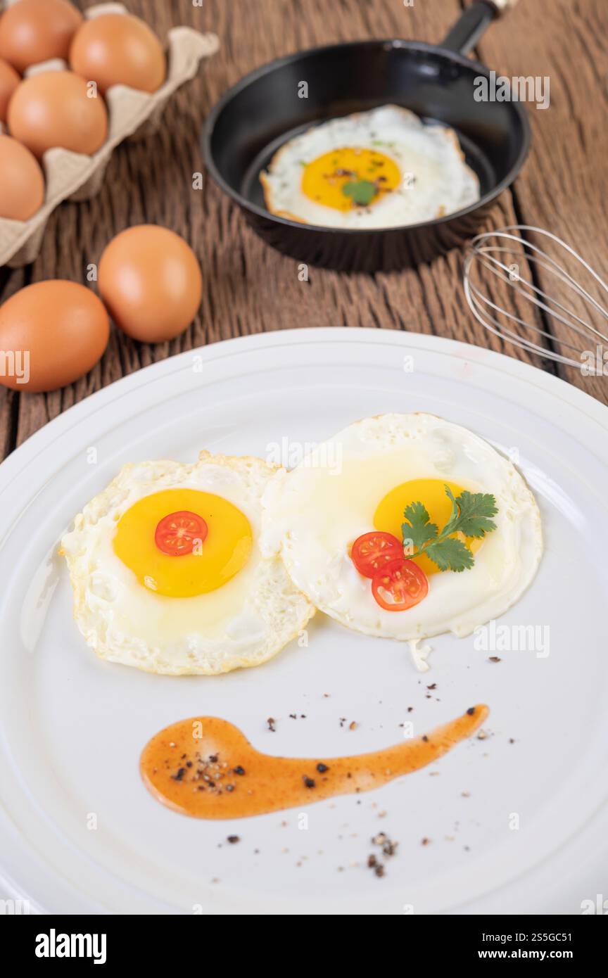 Uova fritte in una padella e uova crude, cibo biologico per una buona salute, ricco di proteine. Foto Stock