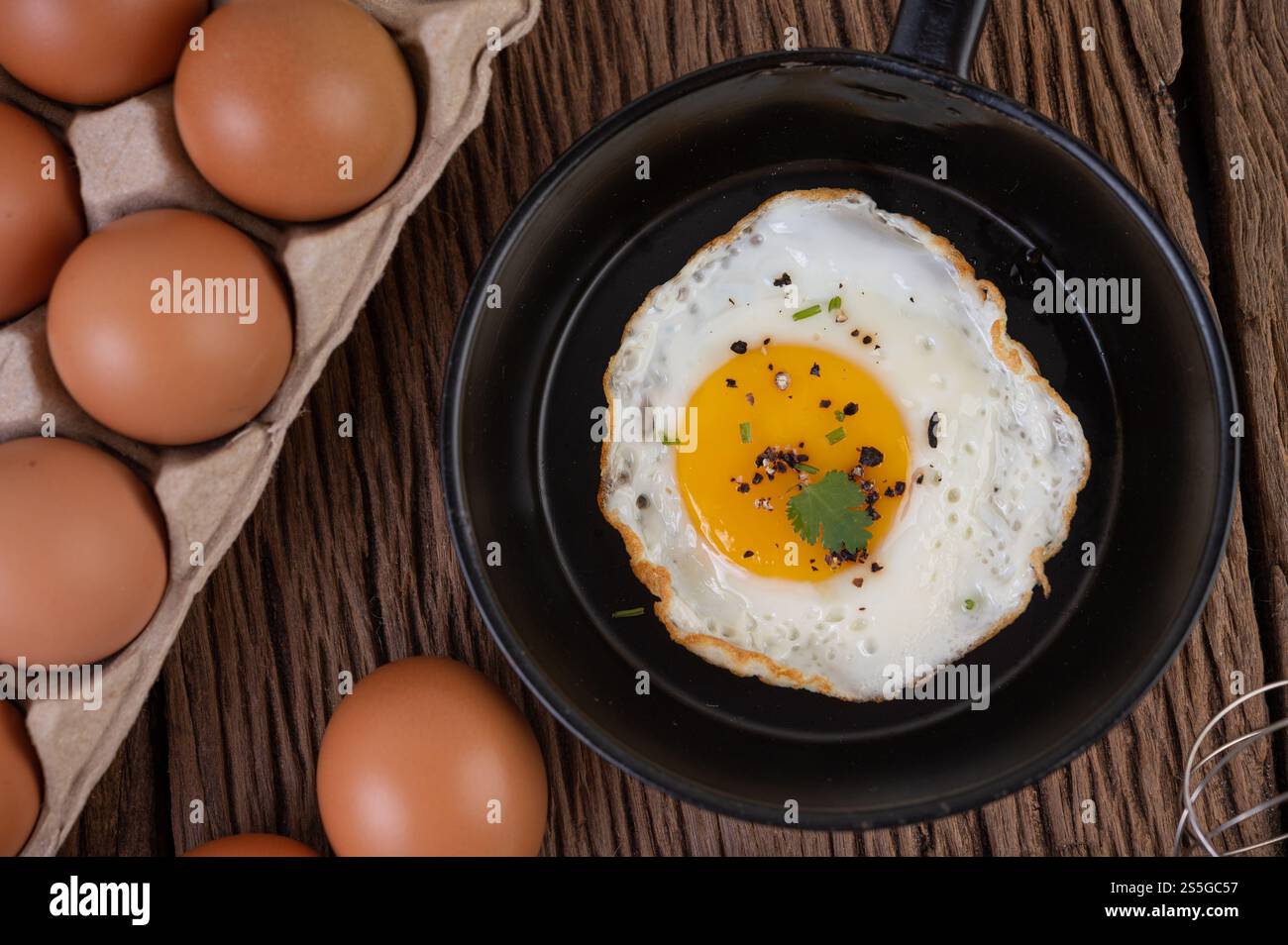 Uova fritte in una padella e uova crude, cibo biologico per una buona salute, ricco di proteine Foto Stock