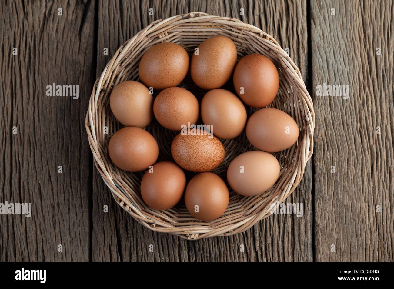 Disporre le uova in un cestino di legno su un pavimento di legno. Vista dall'alto. Foto Stock