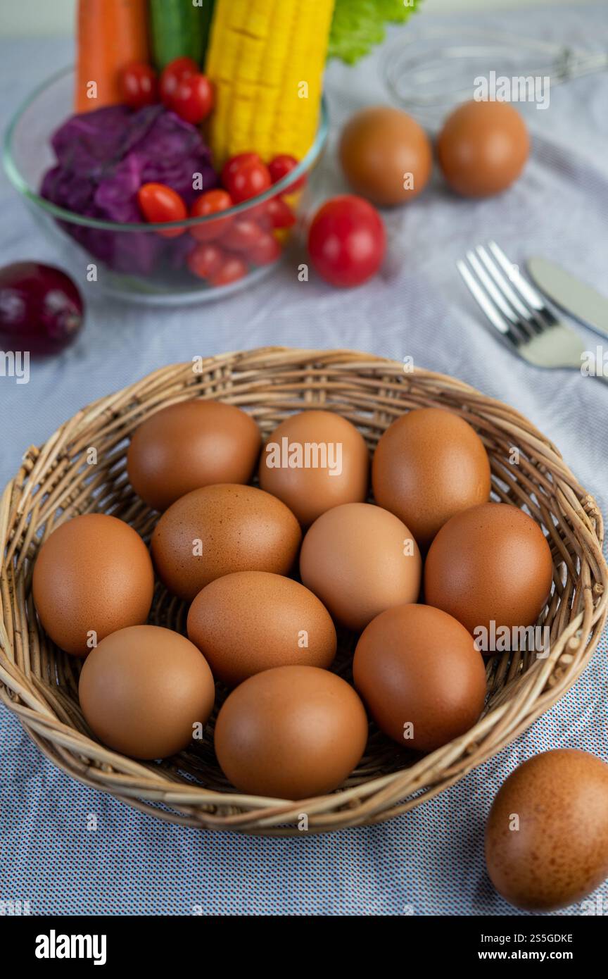 Disporre le uova in un cestino di legno su un pavimento di legno. Messa a fuoco selettiva. Foto Stock