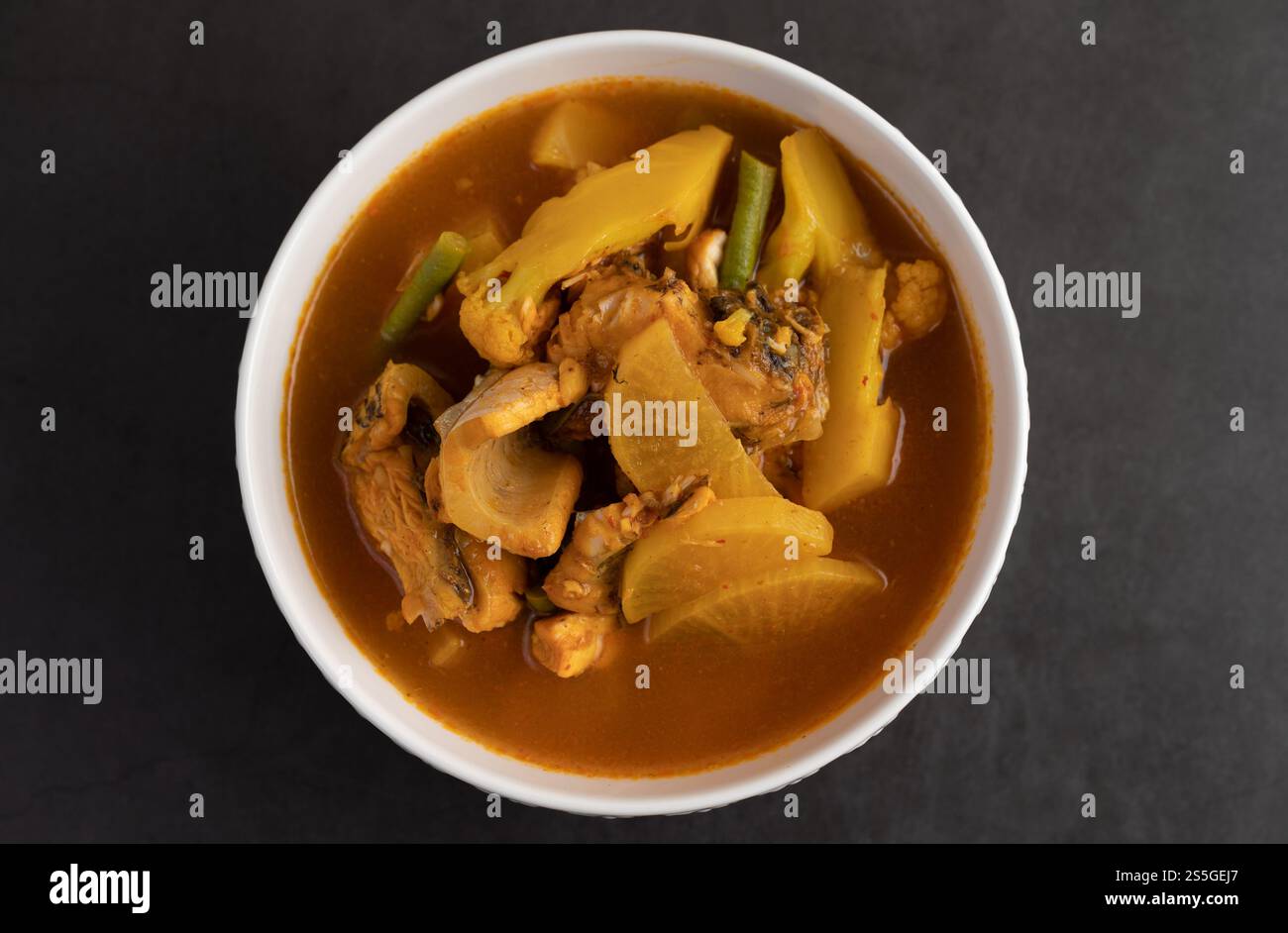 Curry giallo con pesce testa di serpente, cibo tailandese in una ciotola su un piatto. Vista dall'alto. Foto Stock