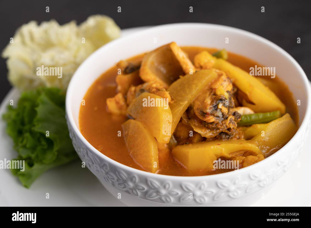 Curry giallo con pesce testa di serpente, cibo tailandese in una ciotola su un piatto con insalata e cavolo bianco fritto. Foto Stock