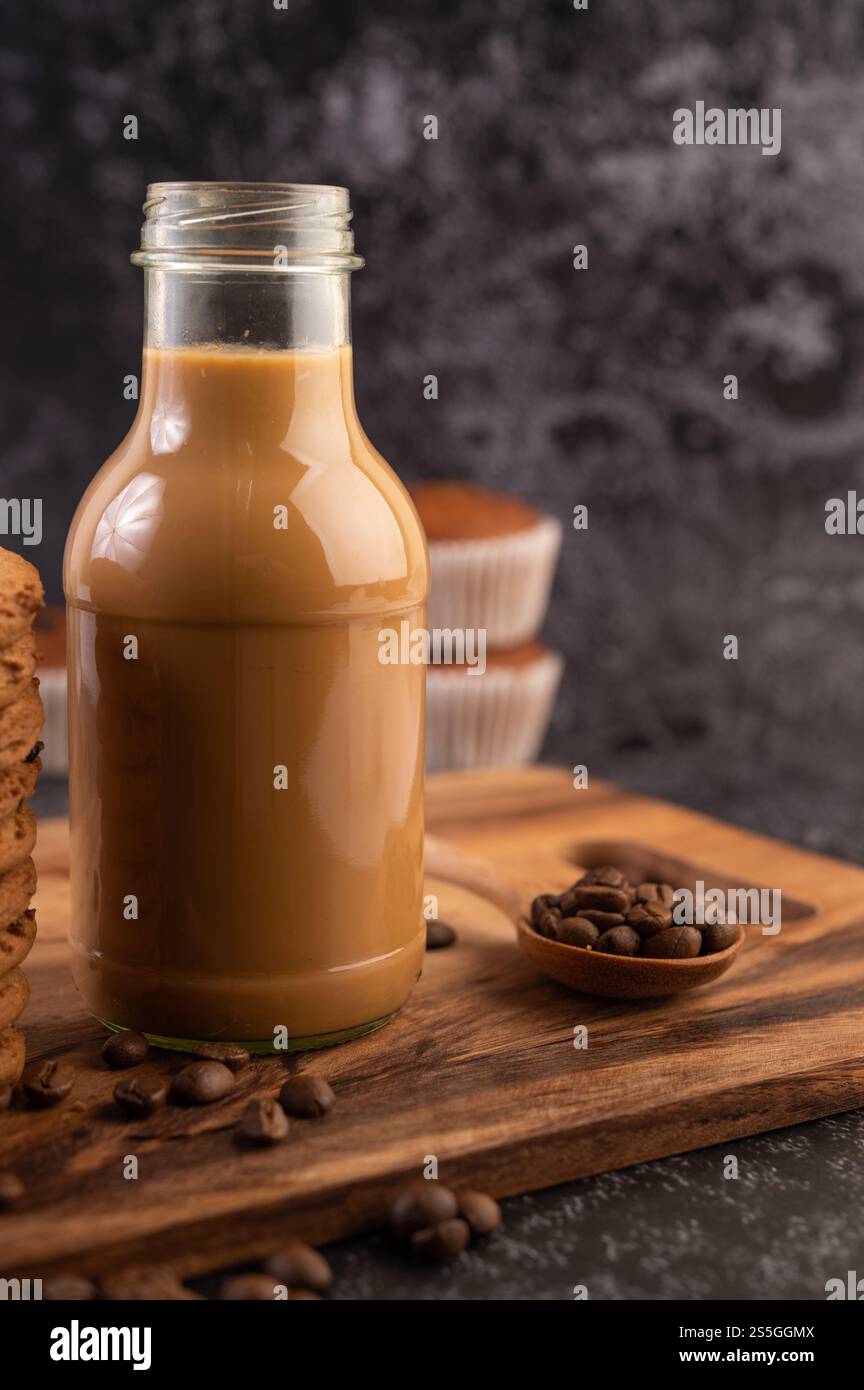 Caffè in bottiglia con chicchi di caffè su un piatto di legno. Messa a fuoco selettiva. Foto Stock