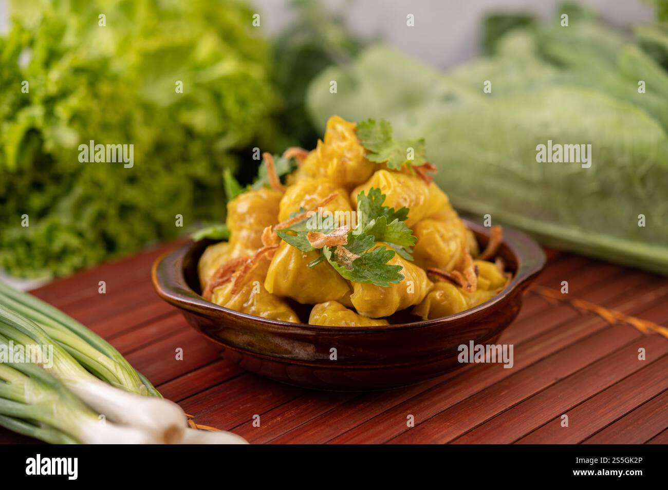 Shumai o Kanom Jeeb o guanciali di maiale al vapore su un piatto, cosparso di coriandolo e cipolle fritte. Foto Stock