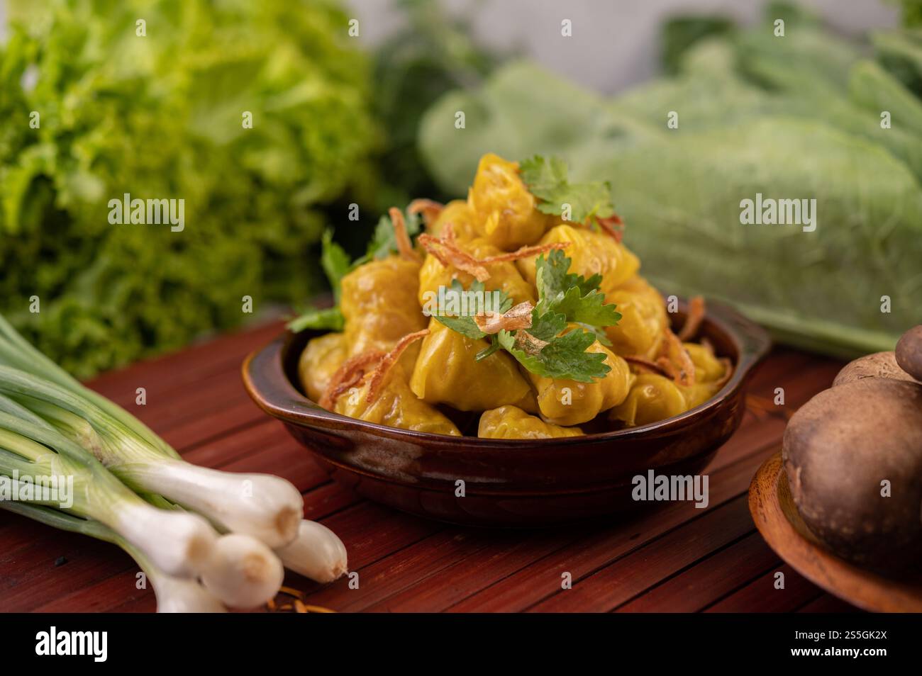 Shumai o Kanom Jeeb o guanciali di maiale al vapore su un piatto, cosparso di coriandolo e cipolle fritte. Foto Stock