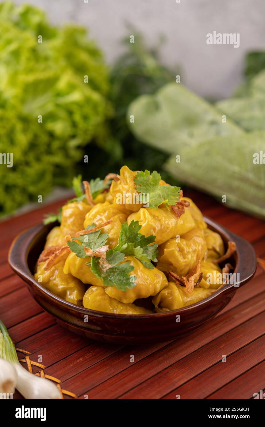 Shumai o Kanom Jeeb o guanciali di maiale al vapore su un piatto, cosparso di coriandolo e cipolle fritte. Foto Stock